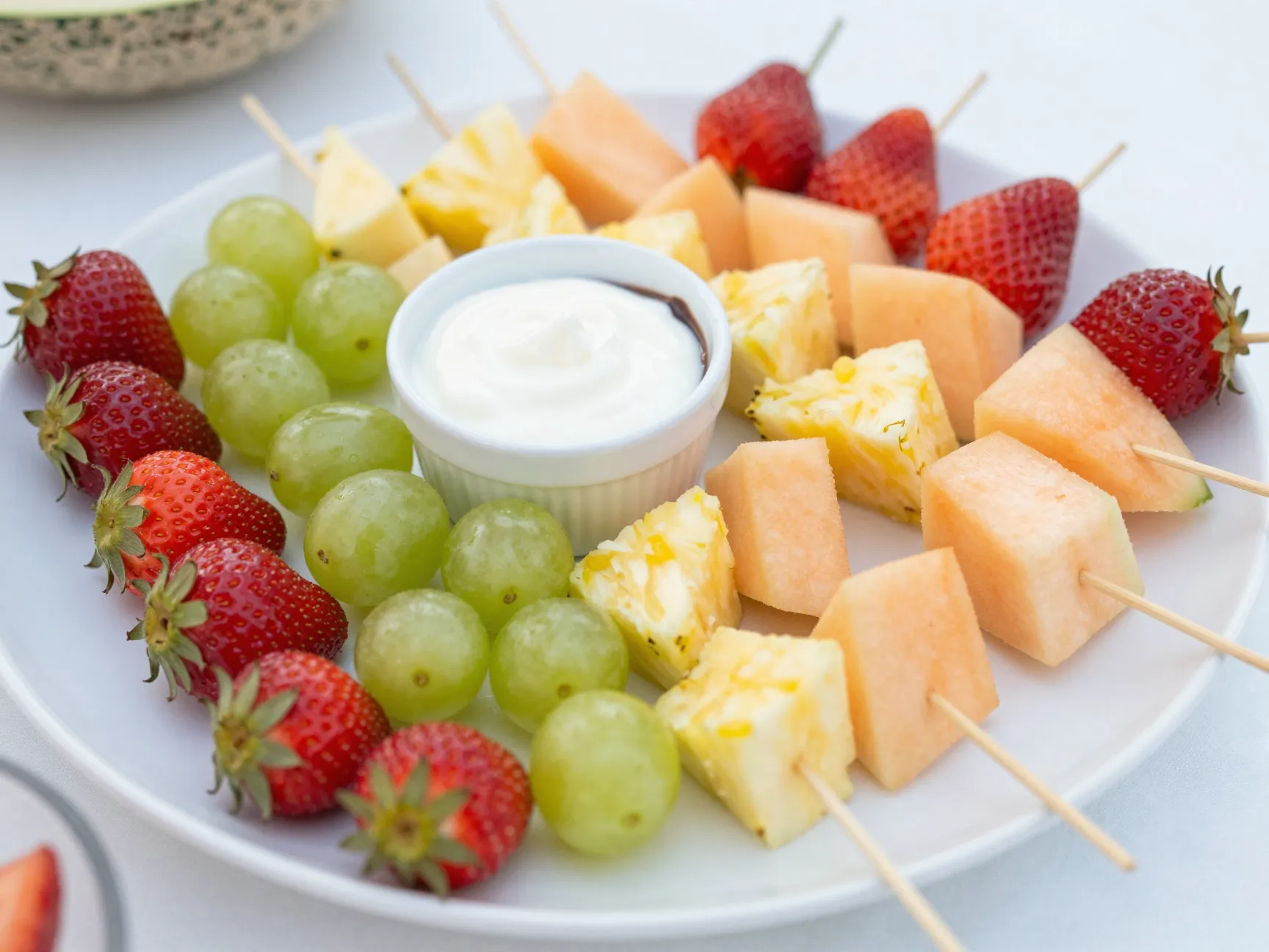 Colorful fruit skewers with two dipping sauces