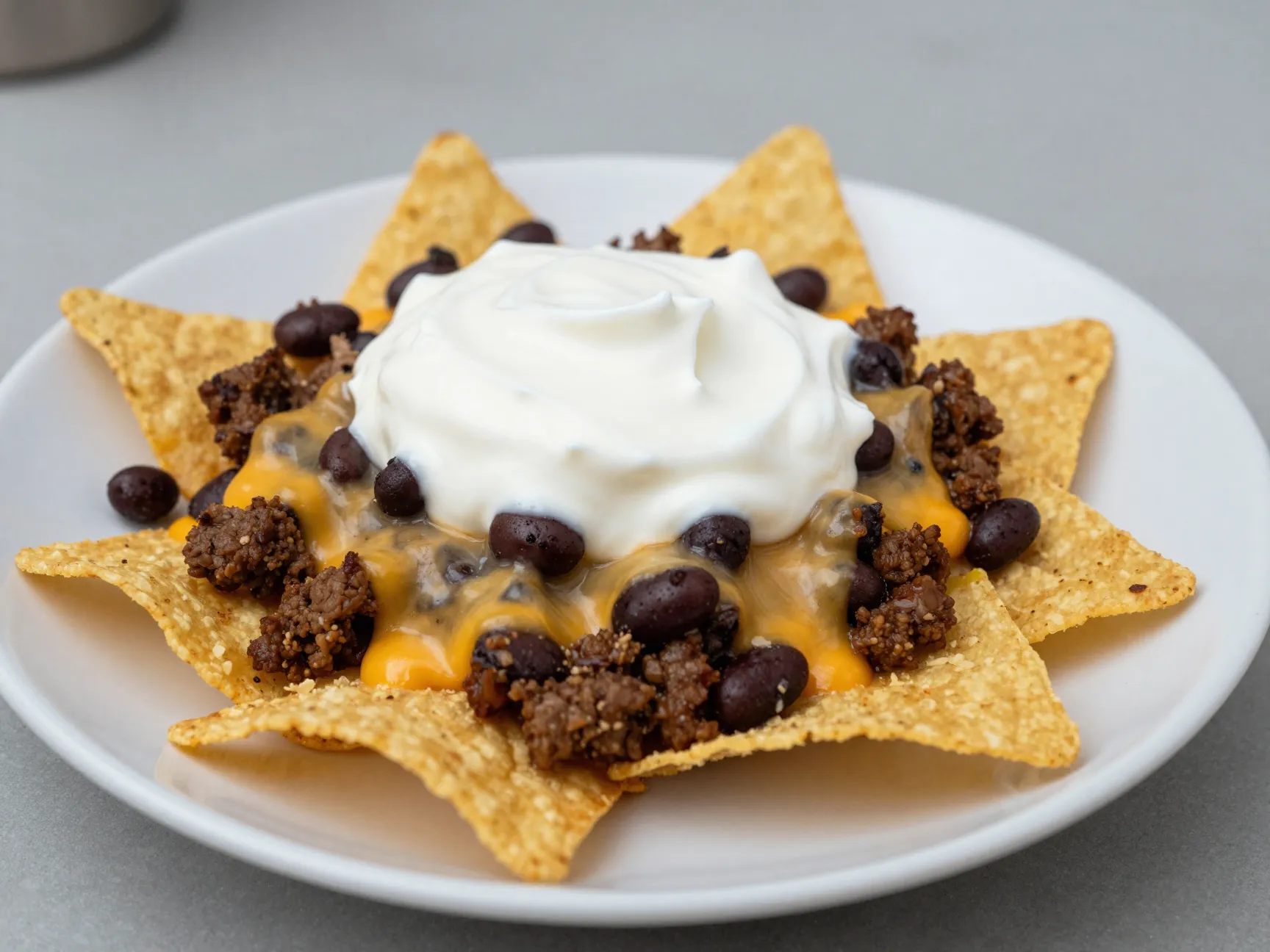 Fully loaded ground beef nachos with black beans and sour cream